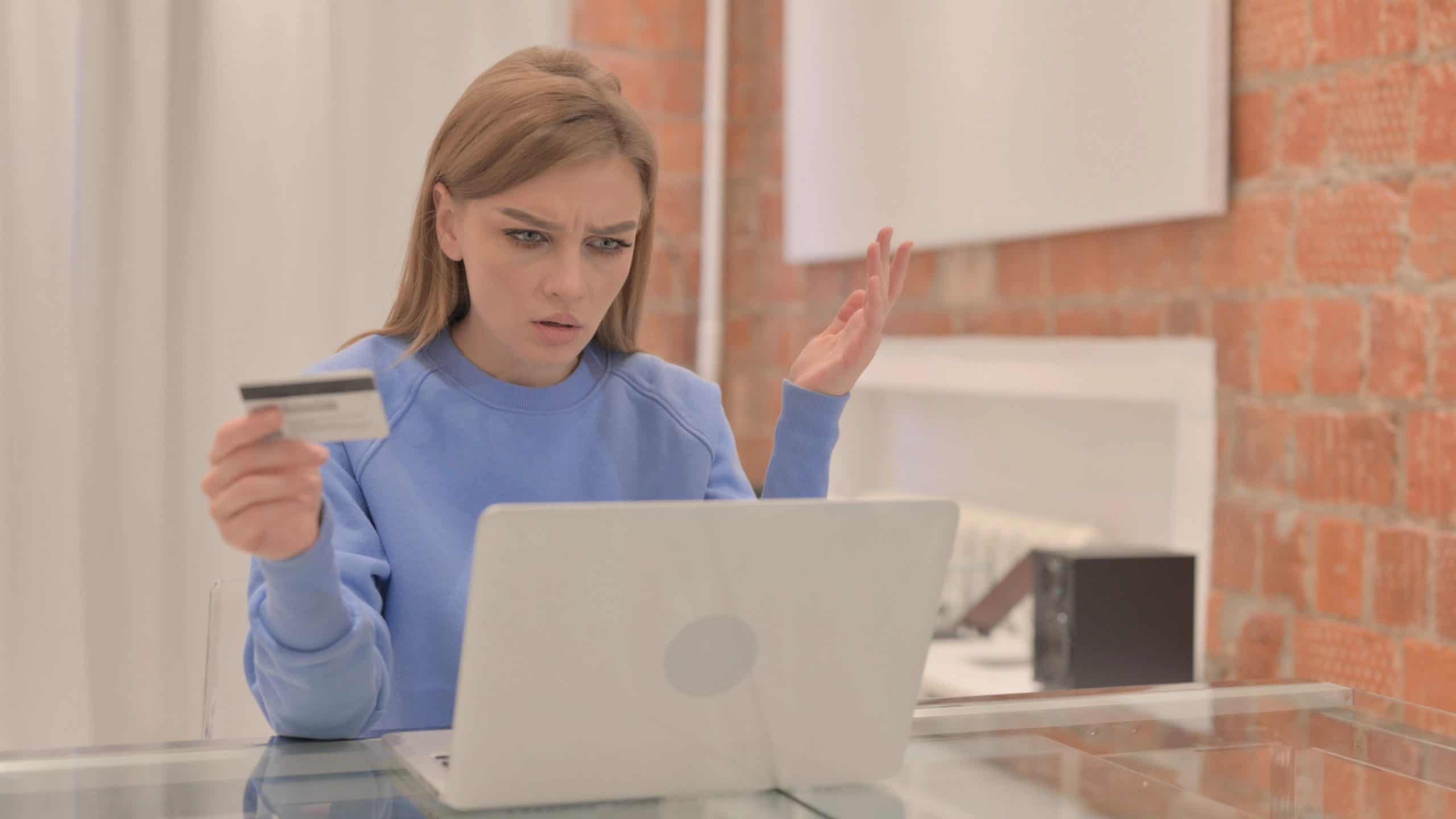 teen in front of laptop holding a credi card. Teaching Teens about credit