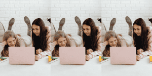 Teen girls sitting laying on the rug around laptop - Money Management Gifts for Teens