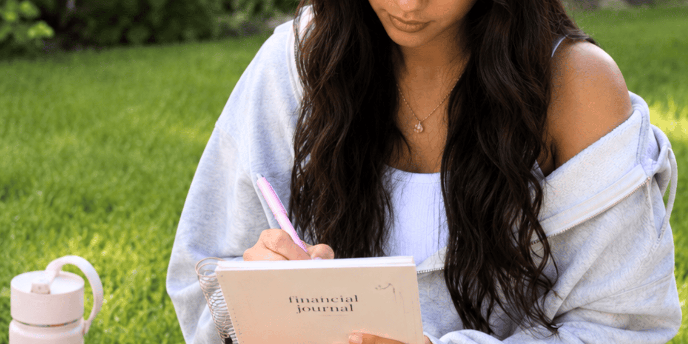 Young female writing in her financial journal - money gifts that teach