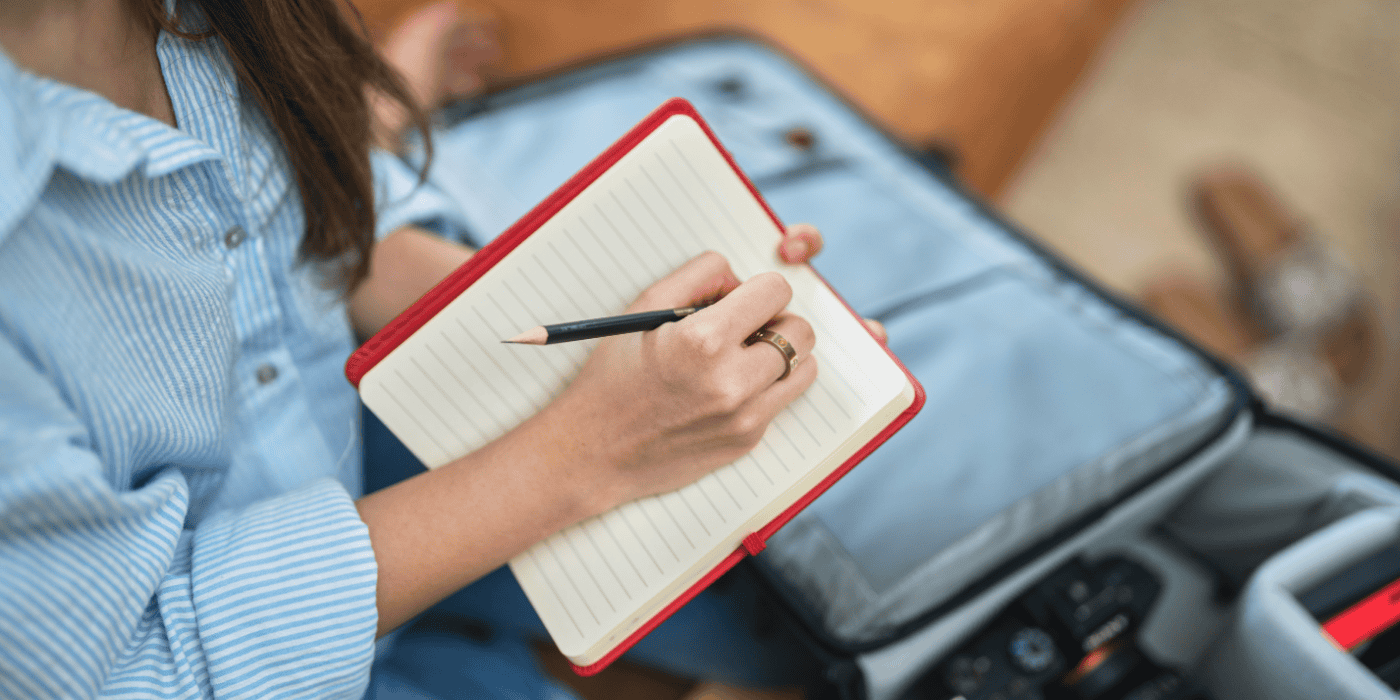 Young girl writing in her red journal